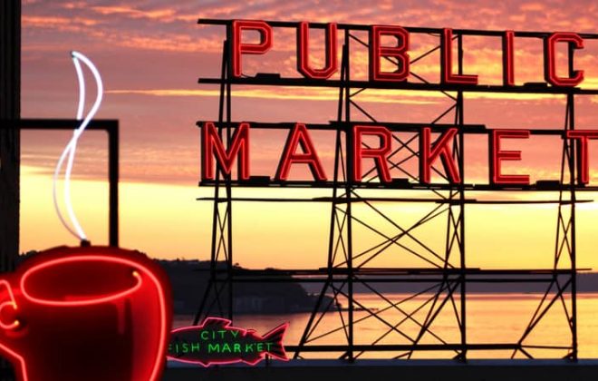 The neon Pike Place Market sign with the sunset in the background